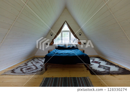 Cozy A-Frame Bedroom Design Featuring Natural Wood Elements and Modern Aesthetics in a Serene Environment with Simple Yet Elegant Decor 128330274