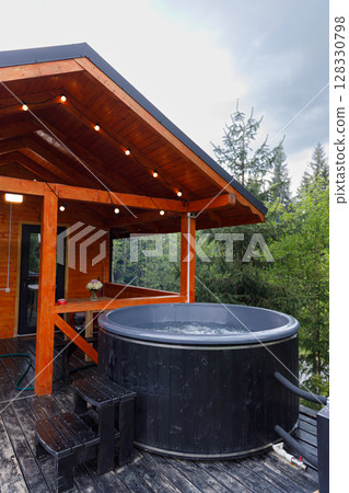 A Relaxing Retreat with a Wooden Deck and Hot Tub Overlooking Nature - Perfect for Leisure and Serenity Amidst the Trees 128330798