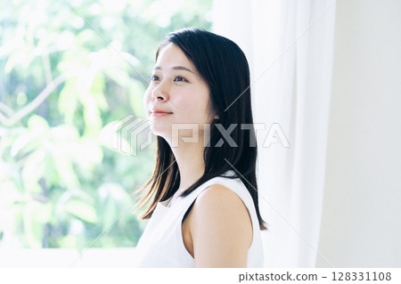 站在窗邊的年輕女子的肖像 128331108