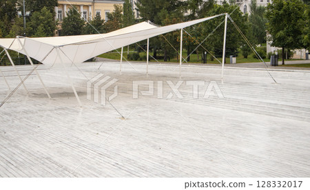 White wood new decking and tarpaulin awning, empty lot in a recreation park White wood new decking and tarpaulin awning, empty lot in a recreation park 128332017