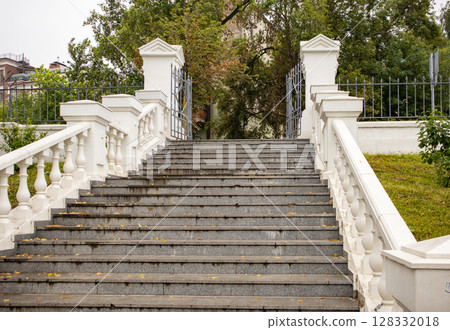 Elegant white stone staircase with balustrades, view from below of the park's open metal gates Elegant white stone staircase with balustrades, view from below of the park's open metal gates 128332018