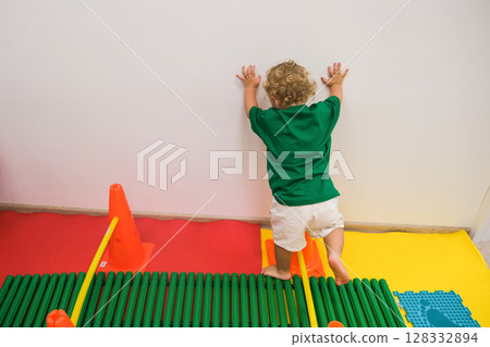 child walking up vertical fitness stairs in kindergarten gym 128332894