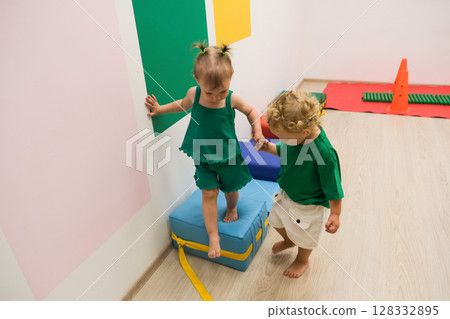 child walking up vertical fitness stairs in kindergarten gym 128332895