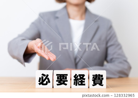 A middle-aged female business woman wearing a suit and a block of necessary expenses 128332965