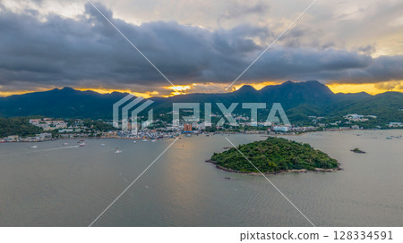 July 5 2025 Coastal Town with Mountainous Backdrop and Ocean Waters 128334591