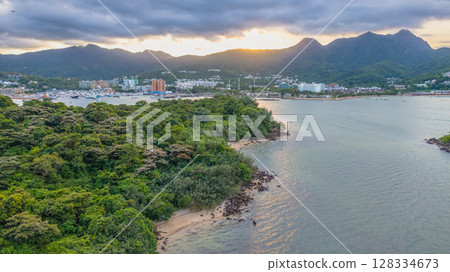 July 5 2025 Coastal Town with Mountainous Backdrop and Ocean Waters 128334673