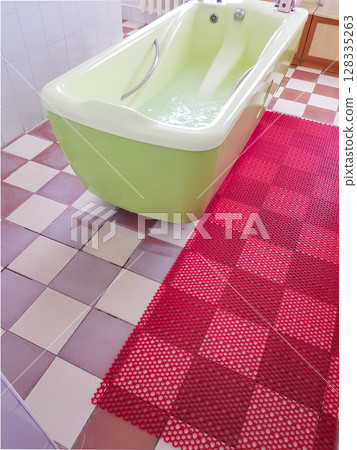 Modern spa room interior with an olive-colored bathtub for water therapy treatments, vertical 128335263