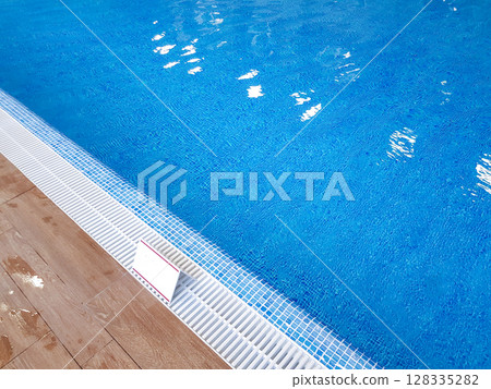 Borderline floor to pool with clear refreshing blue water in the modern resort spa area of the hotel 128335282