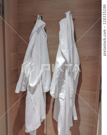 Two white robes on a rack in the hotel bathroom 128335286