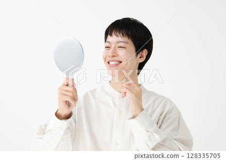 Man looking in a hand mirror Man looking in a hand mirror 128335705