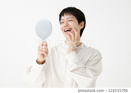 Man looking in a hand mirror Man looking in a hand mirror 128335706