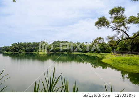 Chiayi City, Taiwan - June 29, 2025: Ningshui's early morning, Lantan water reservoir's light waves, and dense forest of trees. 128335875