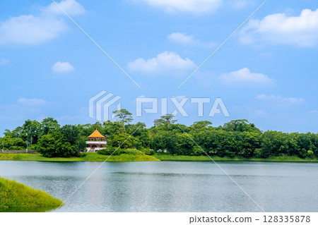 台灣嘉義市 - 2025 年 6 月 29 日:寧水的清晨,蘭潭水庫的波浪和茂密的樹林。 台灣嘉義市 - 2025 年 6 月 29 日:寧水的清晨,蘭潭水庫的波浪和茂密的樹林。 128335878