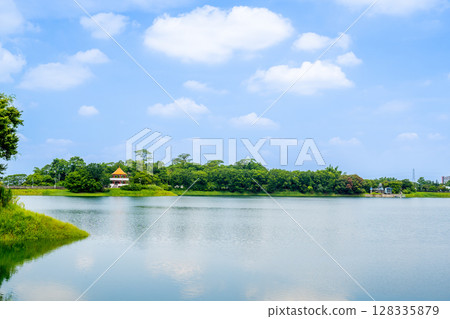 台灣嘉義市 - 2025 年 6 月 29 日：寧水的清晨，蘭潭水庫的波浪和茂密的樹林。 128335879