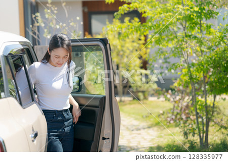 A woman getting off the car 128335977