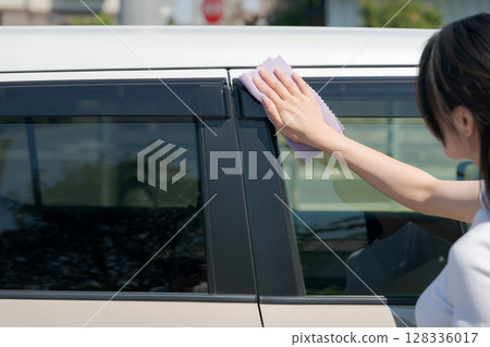 Woman wiping car windows Woman wiping car windows 128336017