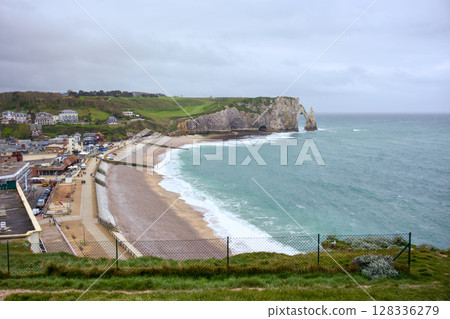 Etretat beach and famous cliffs with town in background Etretat beach and famous cliffs with town in background 128336279