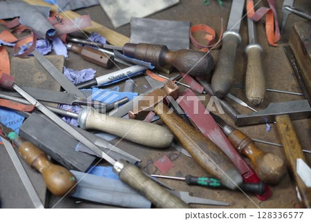 Pile of tools including a variety of knives and scissors Pile of tools including a variety of knives and scissors 128336577