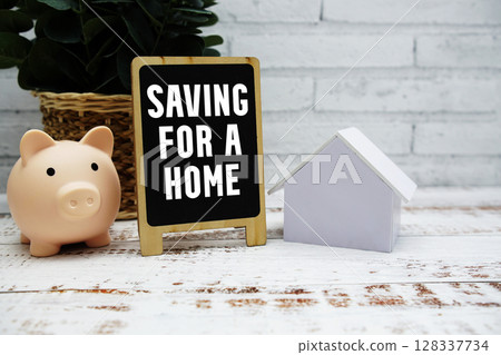 Saving for a Home text with piggy bank and house model on wooden background Saving for a Home text with piggy bank and house model on wooden background 128337734