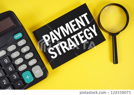 Payment Strategy text with magnifying glass anc calculator on yellow background 128338073
