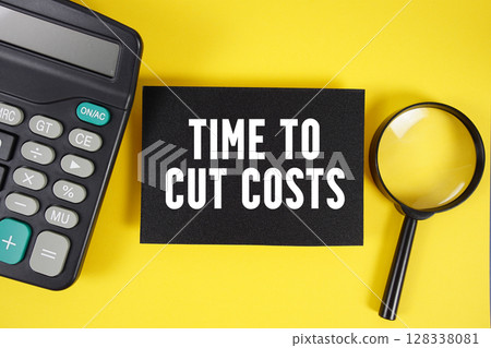 Time to Cut Costs text with magnifying glass anc calculator on yellow background 128338081