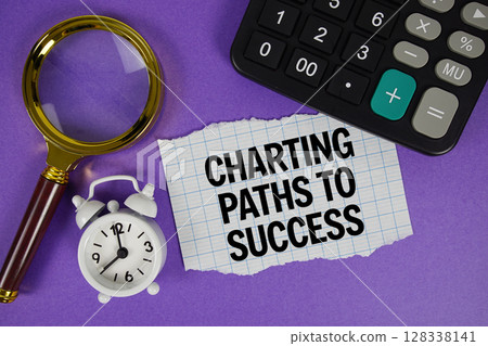 Charting Paths To Success text with alarm clock, magnifying glass anc calculator on purple background 128338141