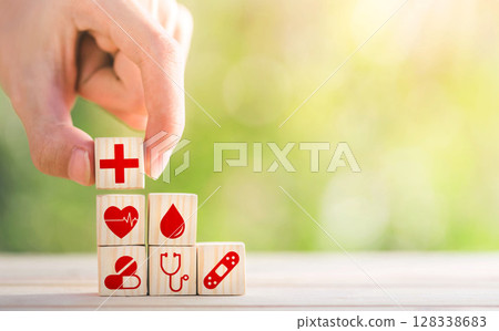 Hand arranged wooden blocks with icons of medical health. health insurance for your health concept. Healthcare medical business. 128338683