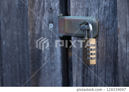 A lock with a key on a wooden door A lock with a key on a wooden door 128339097