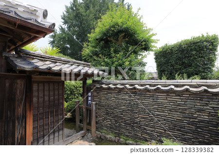 The double-walled gate and the neribei wall to the right of the entrance to the Nomura Takao Family House, a samurai residence in the Doi Kurachu Traditional Buildings Preservation District. The double-walled gate and the neribei wall to the right of the entrance to the Nomura Takao Family House, a samurai residence in the Doi Kurachu Traditional Buildings Preservation District. 128339382