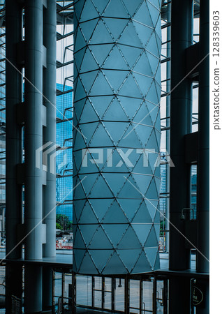 A close-up view of a large glass column inside a modern office building 128339603