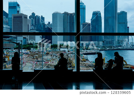 People in building view Hong Kong cityscape, seeing Ferris wheel in distance People in building view Hong Kong cityscape, seeing Ferris wheel in distance 128339605