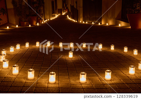 Candlelit Pathway Illuminating a Peaceful Nighttime Street With a Warm Glow Candlelit Pathway Illuminating a Peaceful Nighttime Street With a Warm Glow 128339619