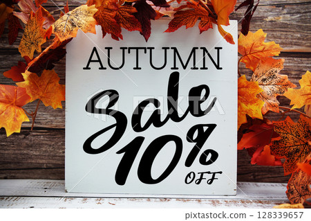 Autumn Sale 10% off text with maple leaf decoration on wooden background Autumn Sale 10% off text with maple leaf decoration on wooden background 128339657