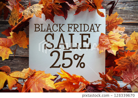 Black Friday Sale 25% off text with maple leaf decoration on wooden background 128339670