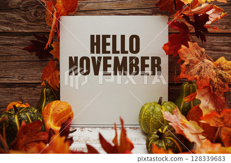 Hello November text with maple leaf decoration on wooden background 128339683