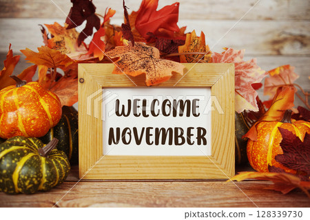 Welcome November text with maple leaf decoration on wooden background 128339730