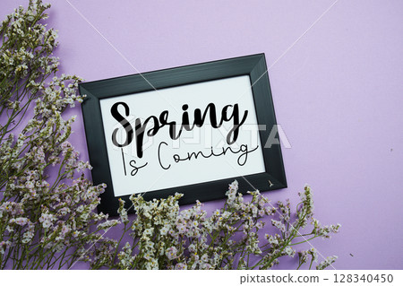 Spring Is Coming text with flowers bouquet decoration on purple background Spring Is Coming text with flowers bouquet decoration on purple background 128340450