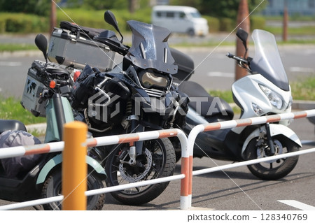Image of a motorcycle in a bicycle parking lot 128340769