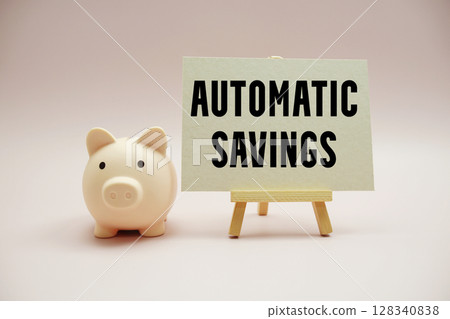 Automatic Savings text and piggy bank for saving on pink background 128340838