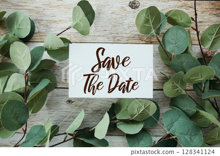 Save the Date text message with artificial green Eucalyptus leaf decoration on wooden background Save the Date text message with artificial green Eucalyptus leaf decoration on wooden background 128341124