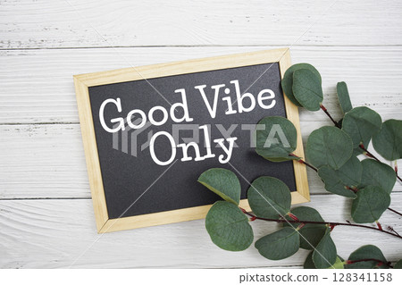 Good Vibe Only text with artificial green leaf eucalyptus on blue background Good Vibe Only text with artificial green leaf eucalyptus on blue background 128341158