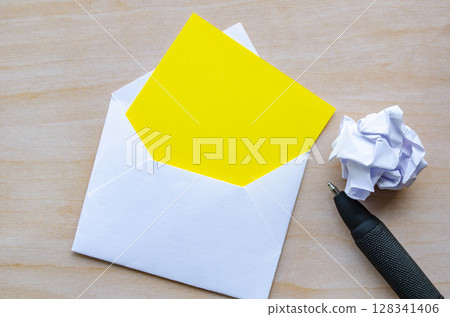 Top view of white notepad with envelope a pen and crumpled paper with customizable space for text or ideas. Resignation concept Top view of white notepad with envelope a pen and crumpled paper with customizable space for text or ideas. Resignation concept 128341406