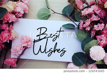 Best Wishes text with flowers decorations on wooden background 128341685