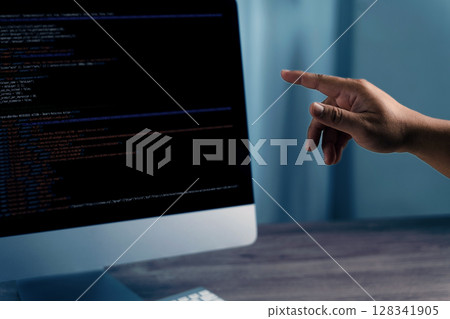 Programming code on representing person pointing computer screen displaying code, indicating programming or software development activity 128341905