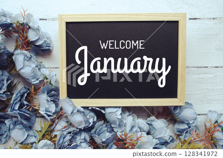Welcome January text with flowers frame decoration top view on wooden background, 128341972