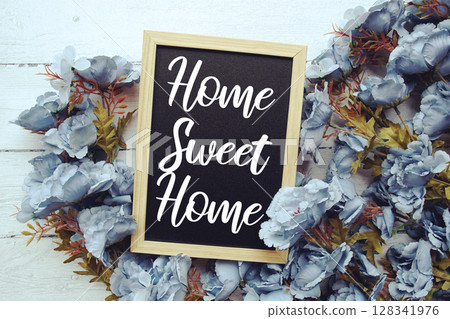 Home Sweet Home text with flowers frame decoration top view on wooden background 128341976