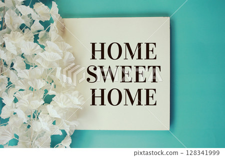 Home Sweet Home text with flowers frame decoration top view on blue background Home Sweet Home text with flowers frame decoration top view on blue background 128341999