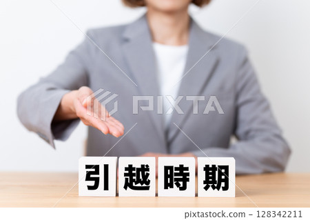A middle-aged female business woman wearing a suit and a block of moving season 128342211
