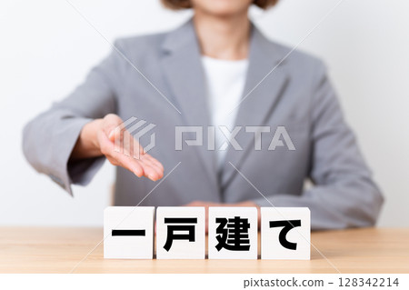 A block of detached houses and a middle-aged business woman wearing a suit 128342214