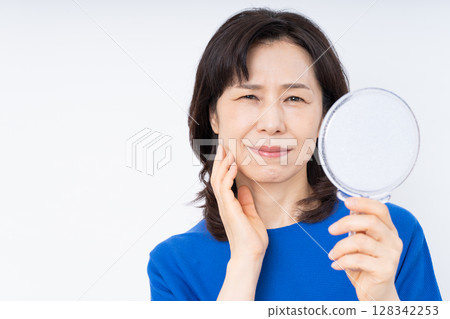 中年婦女拿著鏡子擔心自己的皮膚 128342253